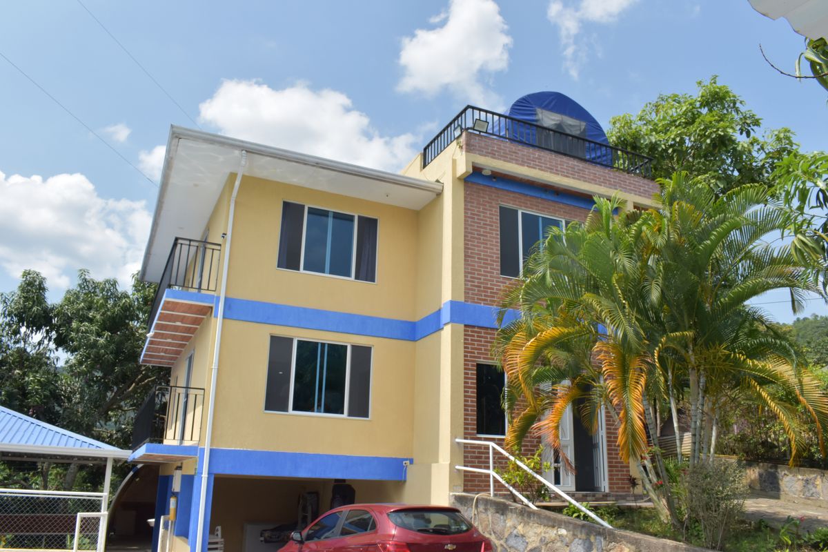 Fachada amarilla con franjas azules de la casa de Guasi